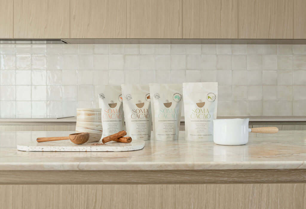 Ceremonial cacao starter pack displayed on a countertop with wooden utensils in a modern kitchen setting.