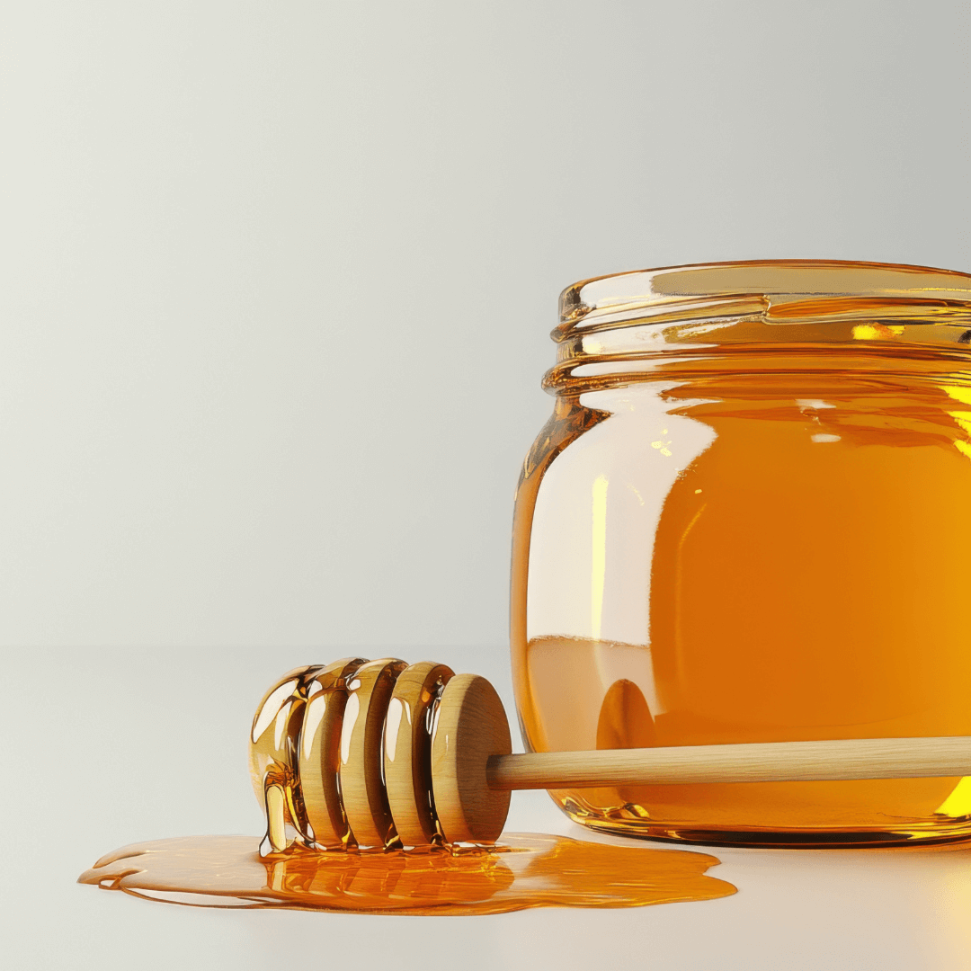 Handcrafted teak honey dipper next to a jar of honey, showcasing its natural beauty and practicality.