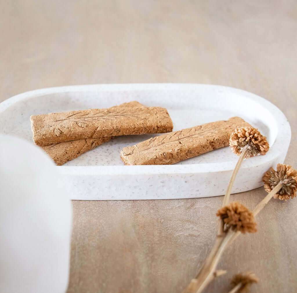 Handcrafted Australian sandalwood incense planks displayed on a white tray with dried flowers, premium quality product.