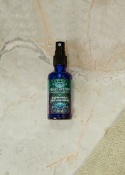 Heart-Opening Cleansing Mist bottle with organic rose geranium and pink lotus essence on a marble surface.
