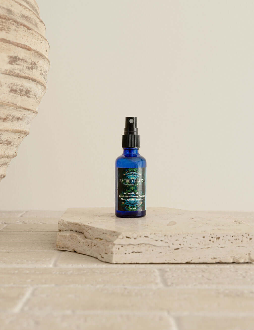 Blue Lotus Meditation Mist bottle on a stone surface, showcasing premium quality for ceremonial cacao experiences.
