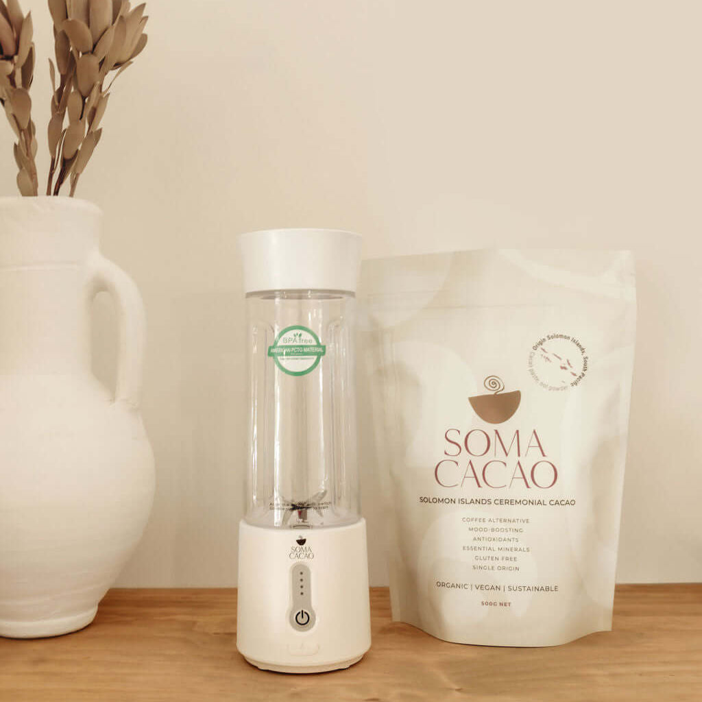 Soma Portable Blender alongside premium ceremonial cacao packaging, ideal for on-the-go blending.