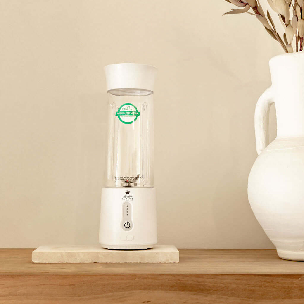 Soma Portable Blender on a wooden shelf, designed for making premium quality ceremonial cacao anywhere.