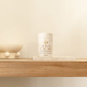 Daintree Cacao Tea by Soma Cacao on wooden shelf with minimalist decor, showcasing premium quality ceremonial cacao.