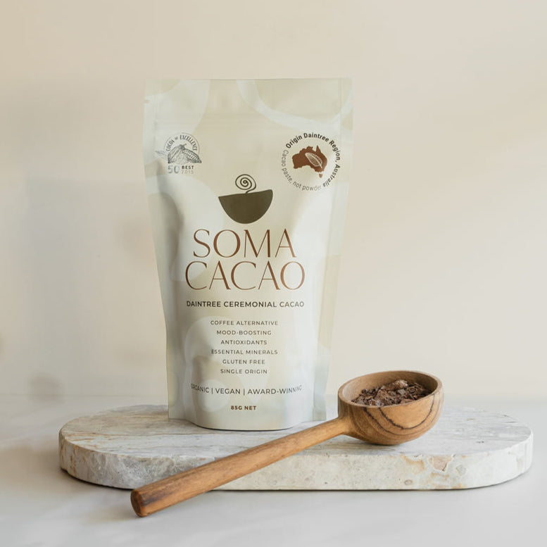Daintree Ceremonial Cacao - Certified Organic, Australian-Grown Cacao packaging with wooden spoon on stone surface.
