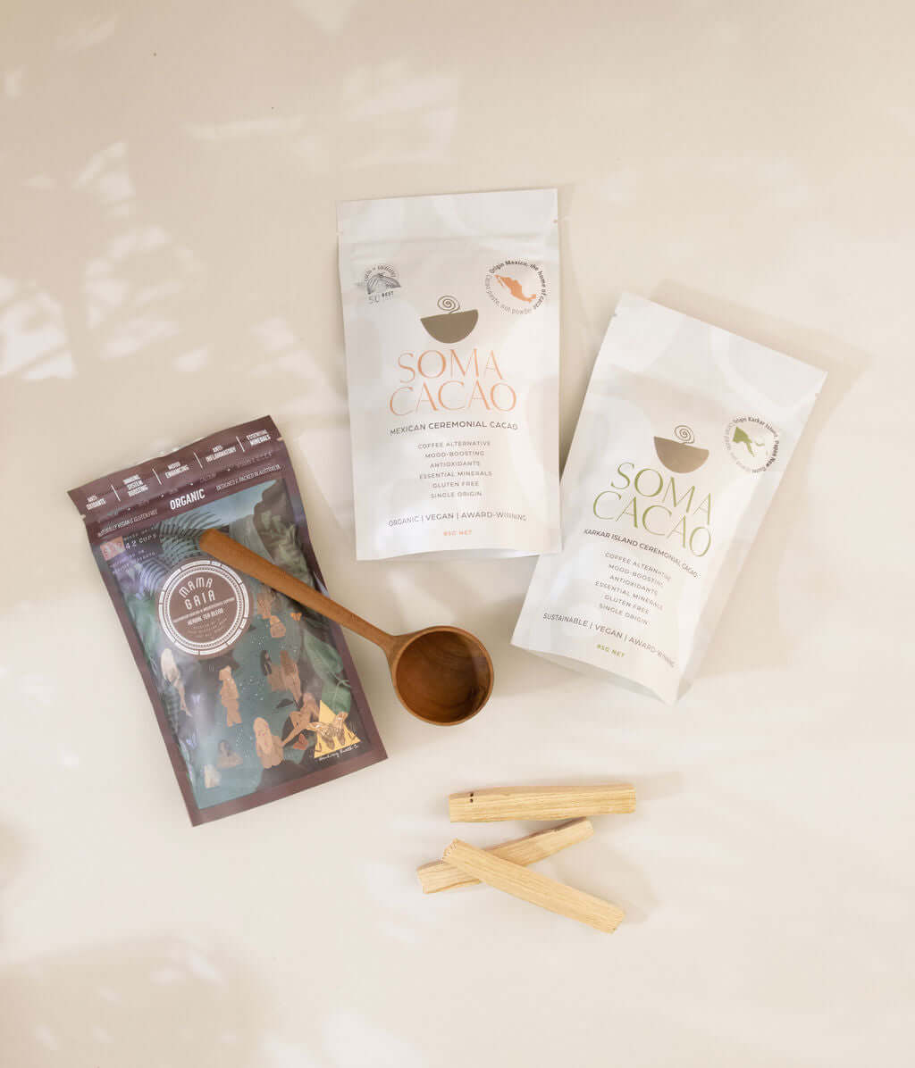 Soma Cacao ceremonial cacao packages with a wooden scoop and herbal ingredients for wellness and healing.