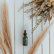 Blue Lotus Flower Essence bottle on a rustic wooden surface with dried flowers, showcasing premium quality and wild-crafted ingredients.